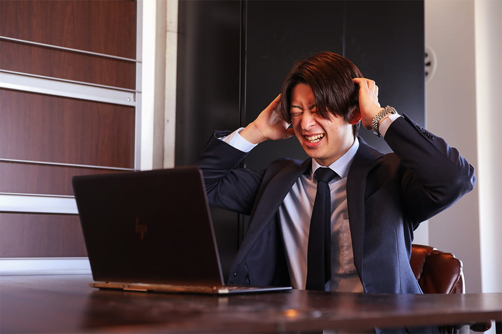 頭をかかえている男性